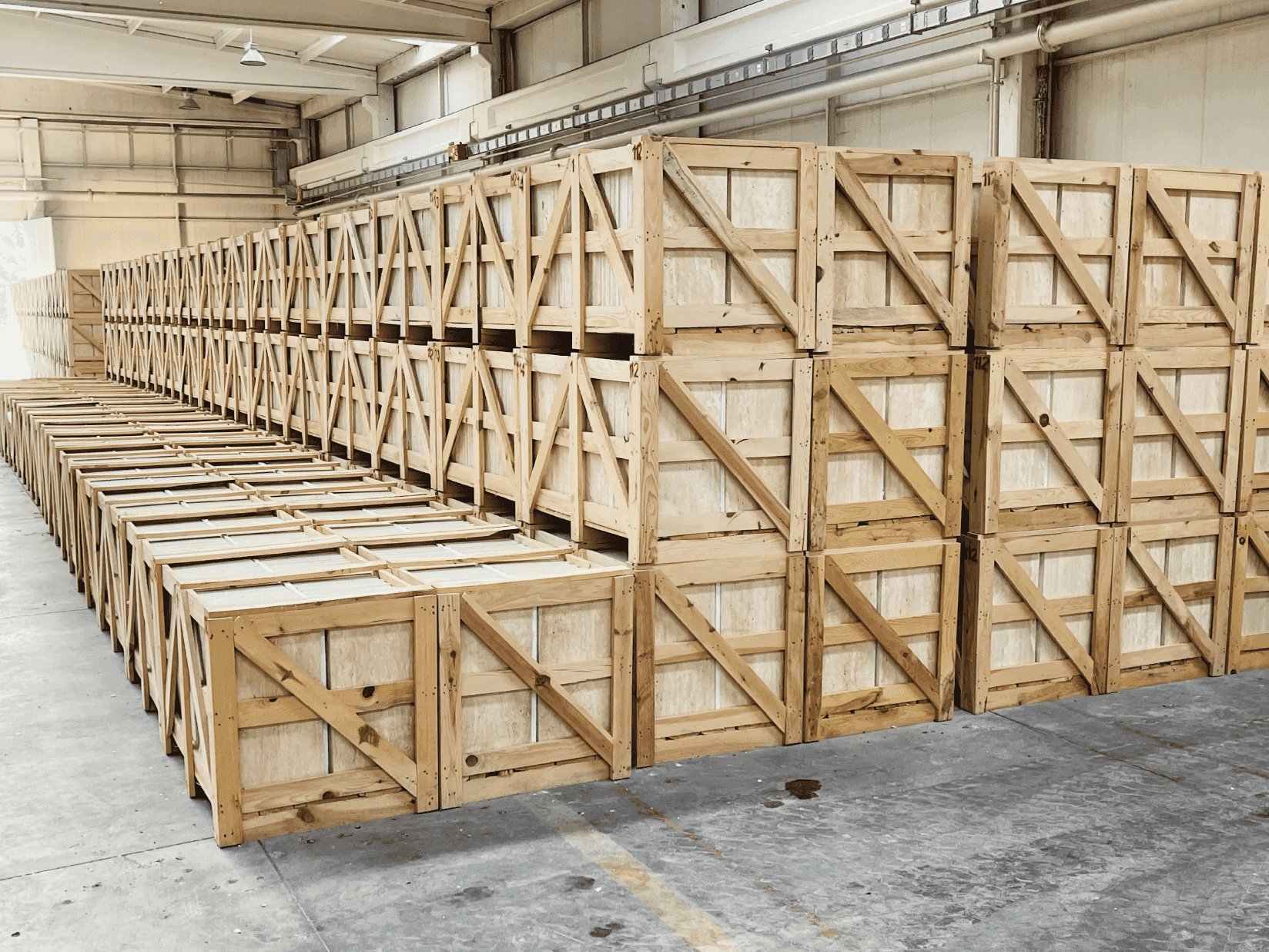 A spacious warehouse filled with numerous wooden crates stacked neatly throughout the interior.