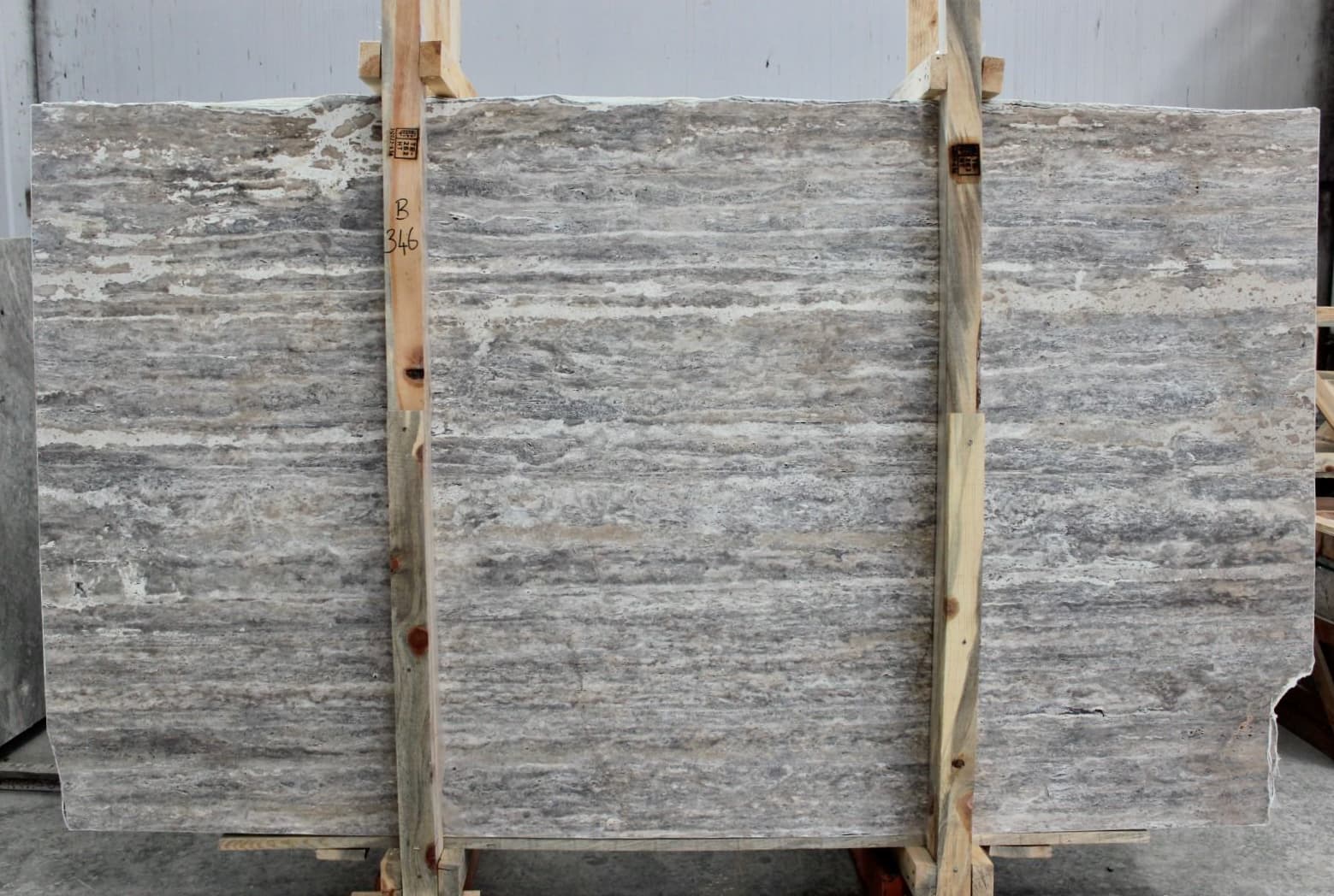 Tabla de Travertino Silver Turco a la Veta con patrón lineal de vetas y estriaciones naturales, asegurada con caballete Tabla de Travertino Silver Turco a la Veta con patrón lineal de vetas y estriaciones naturales, asegurada con caballete