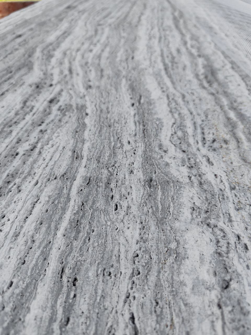 Vein-Cut Silver Travertine close-up showing grey veined pattern with natural porous texture and matte finish Vein-Cut Silver Travertine close-up showing grey veined pattern with natural porous texture and matte finish