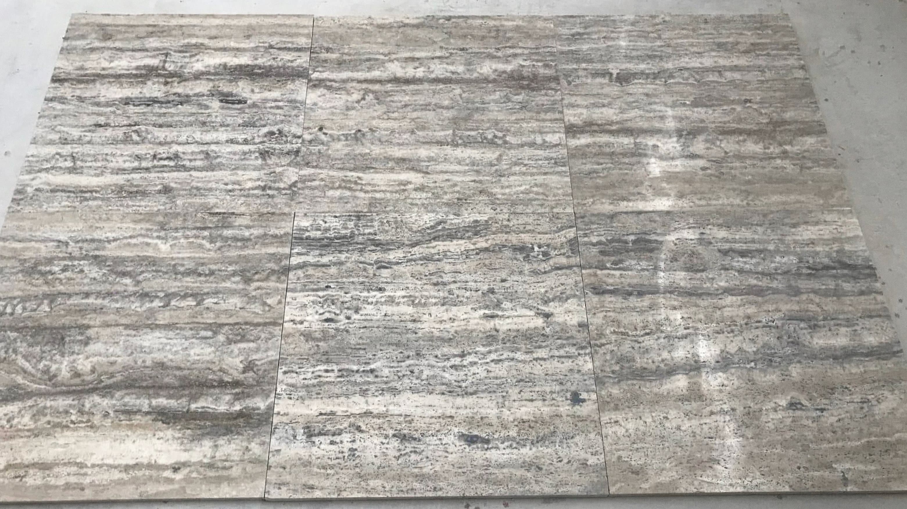 Vein-Cut Silver Travertine tiles displaying grey tones with linear veining pattern and natural travertine texture Vein-Cut Silver Travertine tiles displaying grey tones with linear veining pattern and natural travertine texture